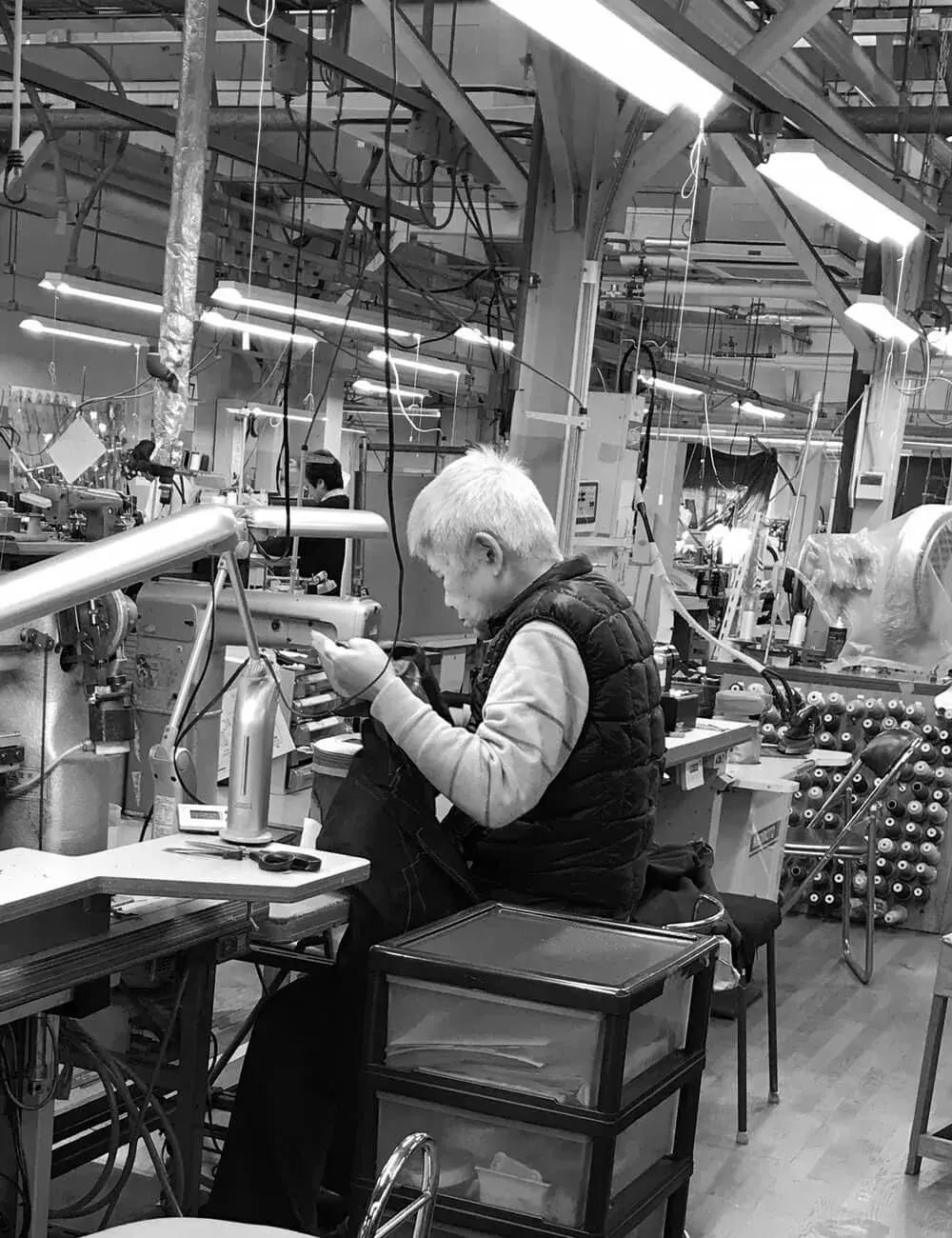 Japanese tailor working at a sewing machine in the production line
