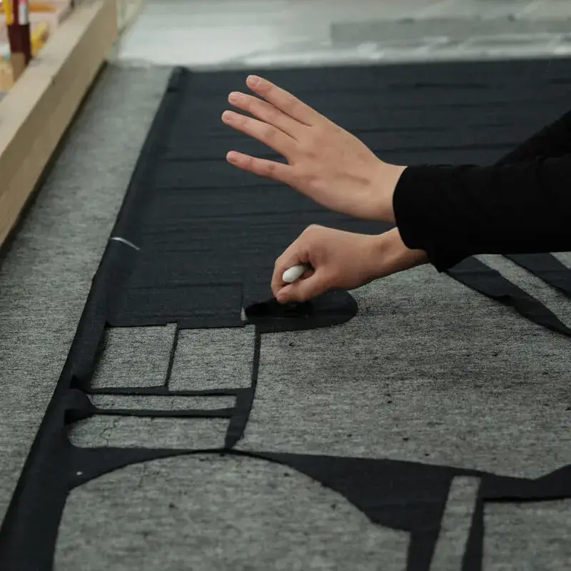 Craftsman marking canvas by hand in a Japanese tailoring workshop